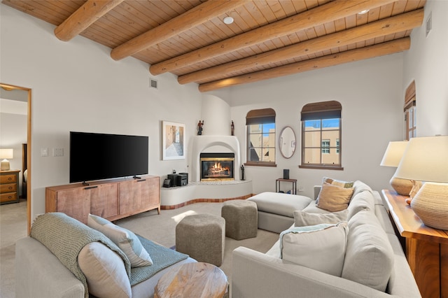 living room with wood ceiling, beam ceiling, a fireplace, and carpet floors