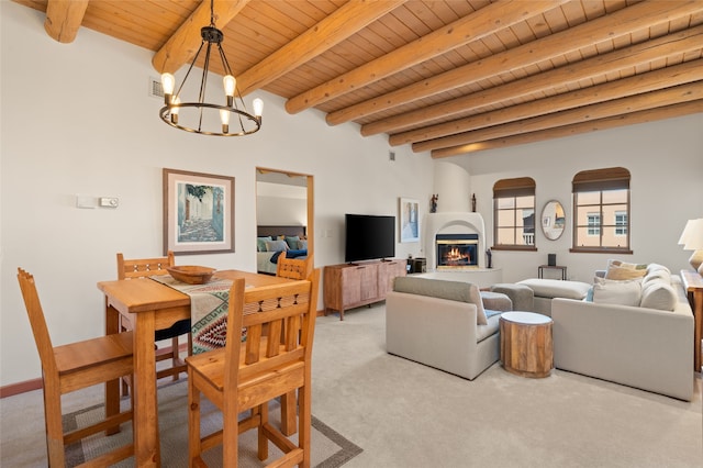 carpeted living room with wood ceiling, a fireplace, beamed ceiling, and an inviting chandelier