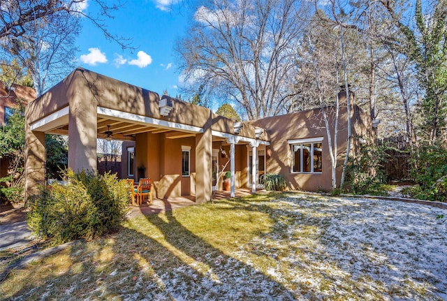 view of front of property with a front yard, ceiling fan, and a patio area