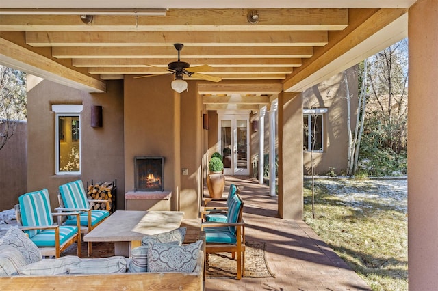 view of patio / terrace featuring french doors, a large fireplace, and ceiling fan