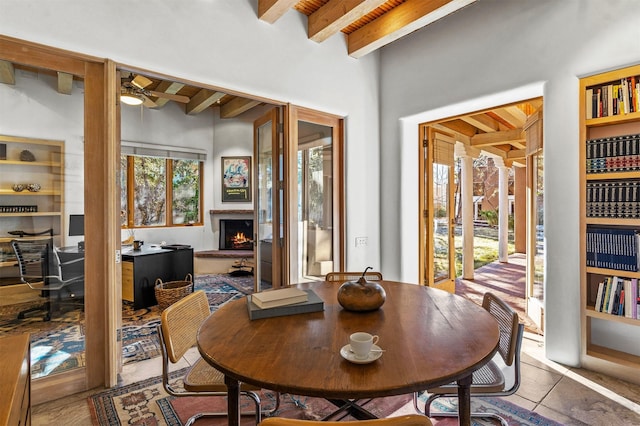 dining space with ceiling fan and beam ceiling