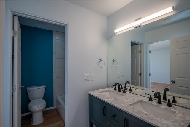 bathroom with hardwood / wood-style floors, toilet, and vanity