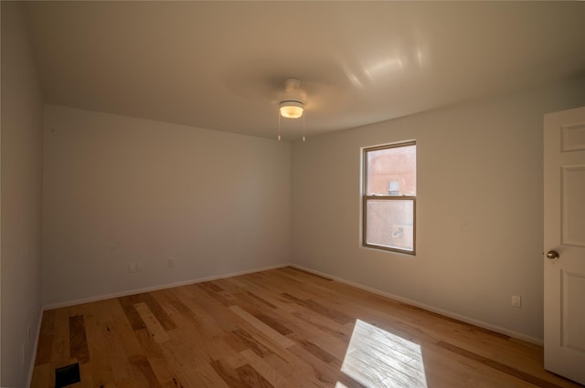 empty room with ceiling fan and light hardwood / wood-style flooring