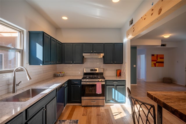 kitchen featuring light stone countertops, tasteful backsplash, dishwasher, sink, and stainless steel gas stove