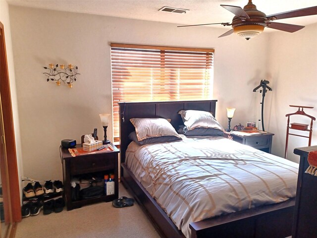 bedroom featuring ceiling fan, carpet, and a textured ceiling