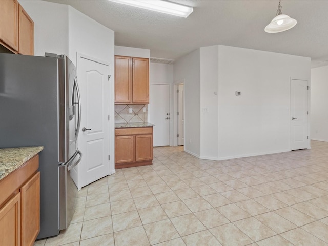 3110 Floras Del Sol, Santa Fe, NM 87507 - kitchen with pendant lighting, stainless steel fridge, backsplash, light tile patterned floors, and light stone counters