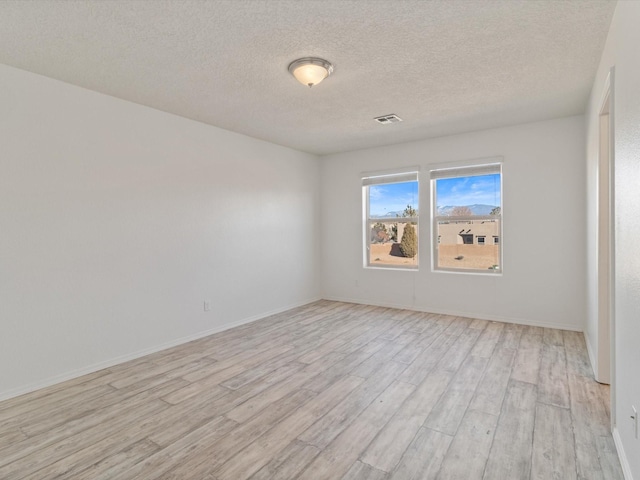 3110 Floras Del Sol, Santa Fe, NM 87507 - unfurnished room featuring a textured ceiling and light wood-type flooring