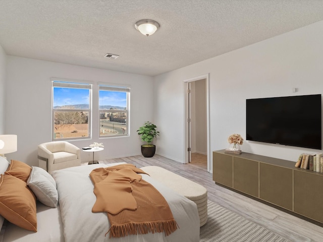 3110 Floras Del Sol, Santa Fe, NM 87507 - bedroom with light hardwood / wood-style floors and a textured ceiling