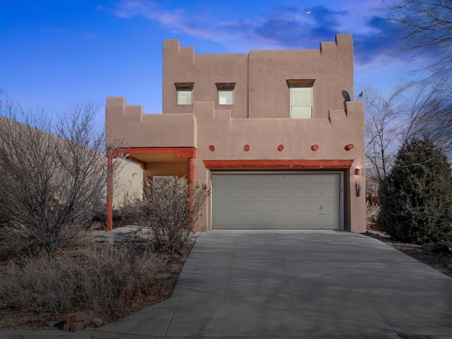 pueblo-style house featuring a garage