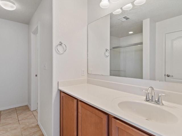 3110 Floras Del Sol, Santa Fe, NM 87507 - bathroom with vanity, a textured ceiling, an enclosed shower, and tile patterned flooring