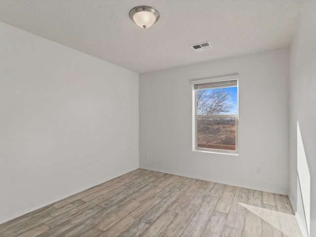 3110 Floras Del Sol, Santa Fe, NM 87507 - unfurnished room featuring light wood-type flooring and a textured ceiling