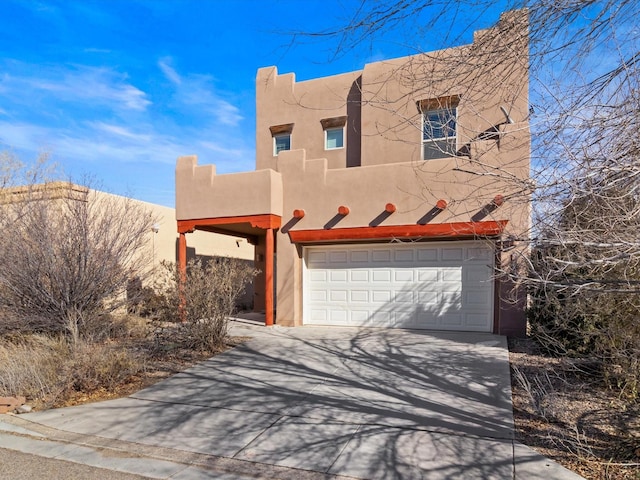 pueblo revival-style home featuring a garage