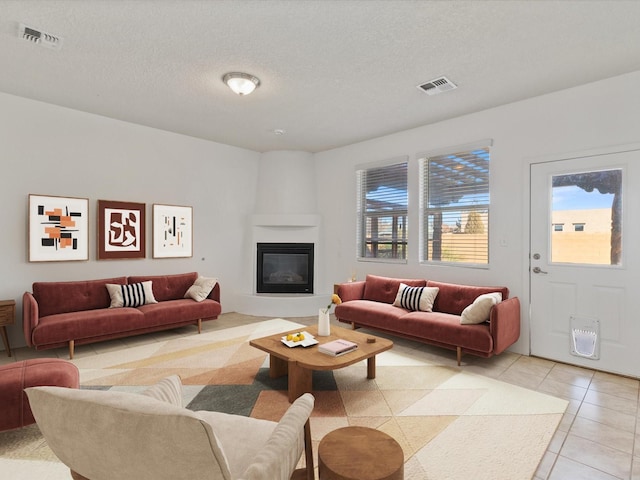 3110 Floras Del Sol, Santa Fe, NM 87507 - living room featuring a large fireplace, light tile patterned floors, and a textured ceiling