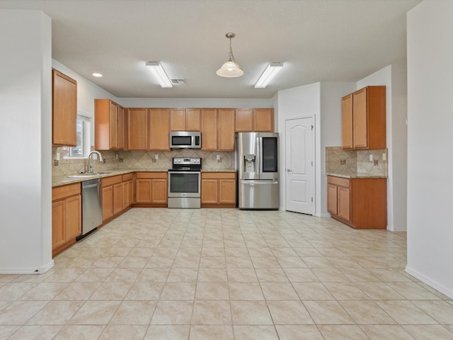 3110 Floras Del Sol, Santa Fe, NM 87507 - kitchen with light stone countertops, appliances with stainless steel finishes, light tile patterned floors, sink, and pendant lighting