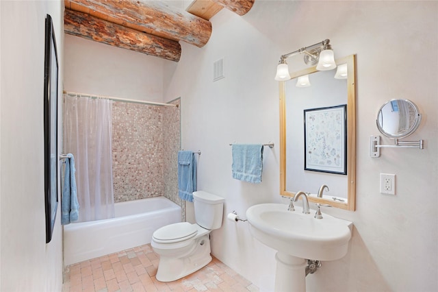 bathroom featuring toilet, beam ceiling, and shower / bath combo