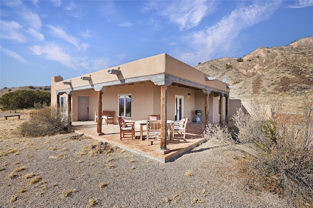 back of house with a mountain view and a patio area