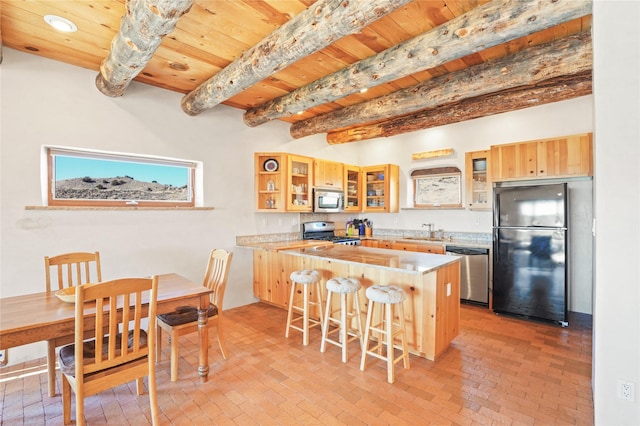 kitchen featuring sink, a breakfast bar area, appliances with stainless steel finishes, kitchen peninsula, and beamed ceiling