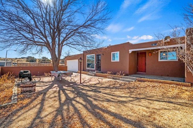 view of front facade featuring a garage and a fire pit