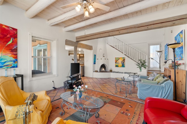 living room featuring beamed ceiling, ceiling fan, light tile patterned floors, and wood ceiling