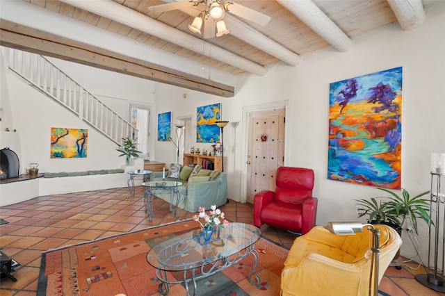 living room with ceiling fan, beam ceiling, wooden ceiling, and tile patterned floors