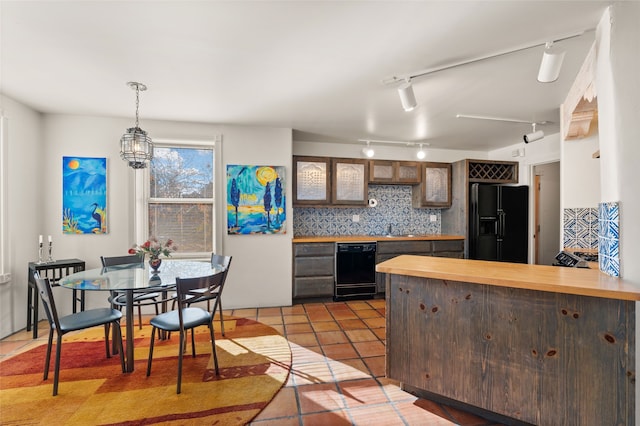 kitchen featuring decorative light fixtures, dark tile patterned flooring, decorative backsplash, black appliances, and track lighting