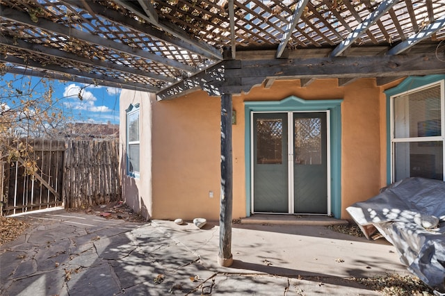 entrance to property featuring a pergola and a patio area