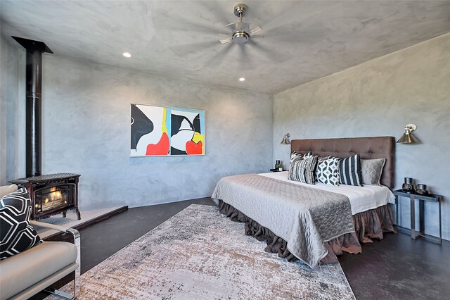 bedroom featuring a wood stove and ceiling fan