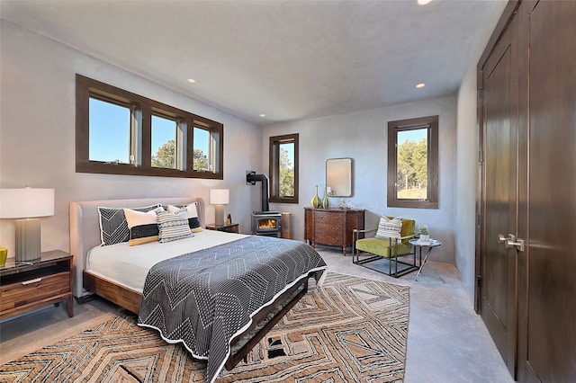 bedroom with a wood stove and light colored carpet