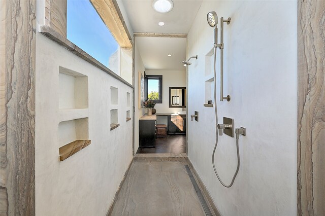 bathroom featuring vanity, concrete floors, and walk in shower