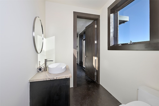 bathroom featuring vanity, concrete floors, and toilet