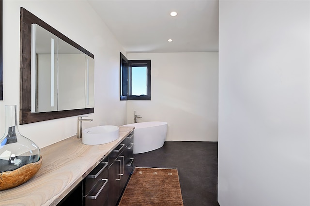 bathroom featuring vanity, concrete floors, and a washtub