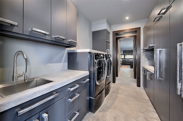 washroom with cabinets, separate washer and dryer, and sink