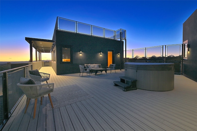 deck at dusk with a hot tub and outdoor lounge area