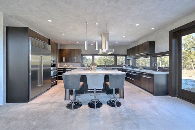 kitchen with pendant lighting, sink, island exhaust hood, a kitchen island, and beverage cooler