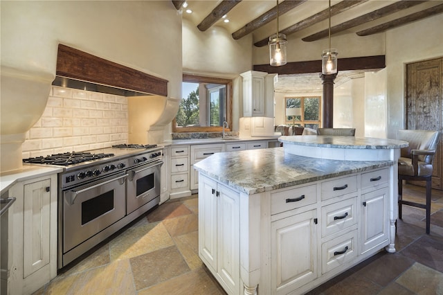 kitchen with double oven range, a center island, white cabinets, and beam ceiling