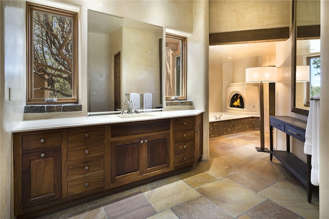 bathroom featuring vanity, a tub, and a wealth of natural light