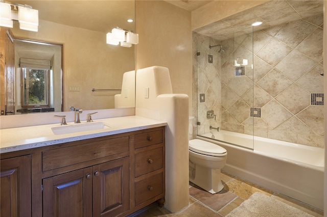 full bathroom featuring tiled shower / bath, vanity, and toilet