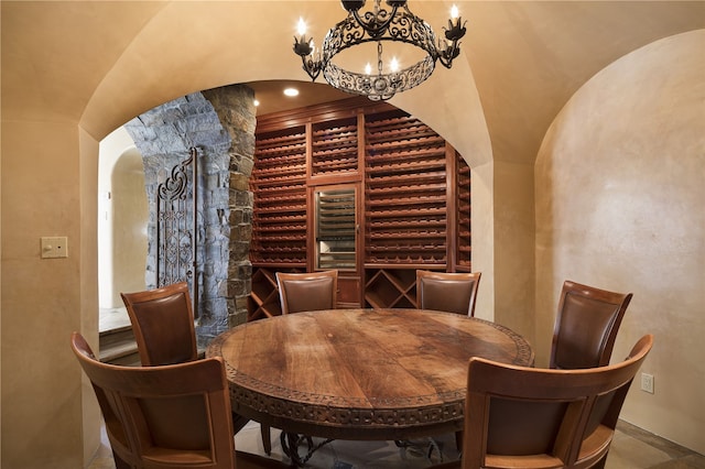 wine area with vaulted ceiling and a notable chandelier