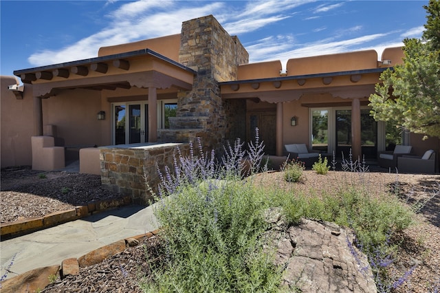 back of house featuring outdoor lounge area and a patio