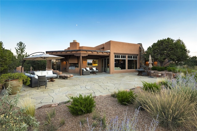 rear view of house featuring outdoor lounge area and a patio