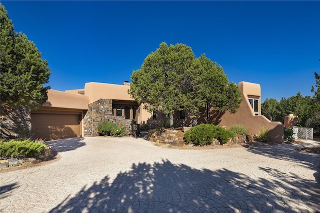 pueblo-style home featuring a garage