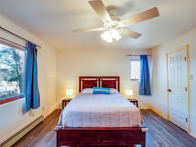 bedroom featuring a baseboard heating unit, hardwood / wood-style floors, and ceiling fan