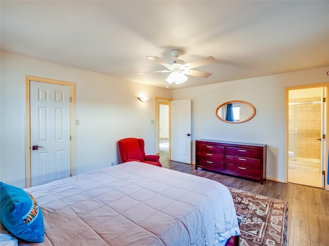 bedroom featuring light hardwood / wood-style floors, ceiling fan, and ensuite bathroom