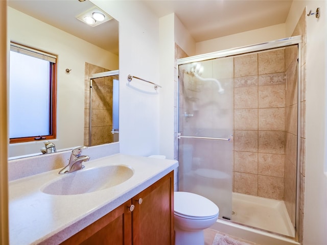 bathroom with an enclosed shower, vanity, and toilet