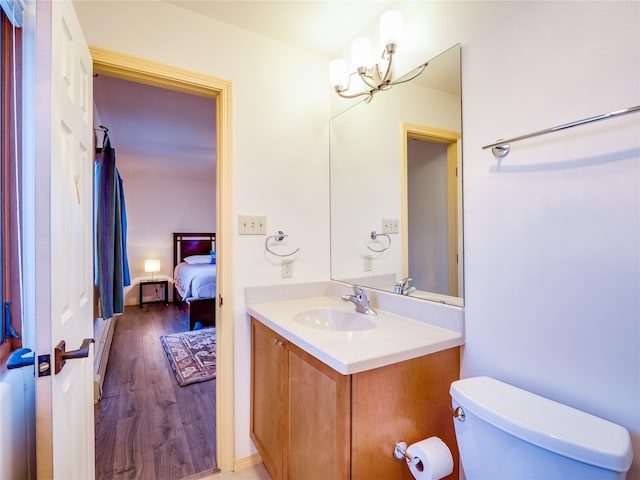 bathroom with vanity, hardwood / wood-style floors, a chandelier, and toilet