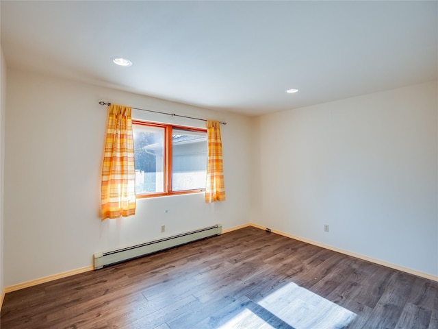 empty room with hardwood / wood-style flooring and baseboard heating