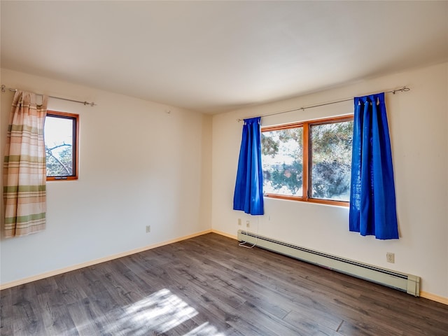 unfurnished room with wood-type flooring, a healthy amount of sunlight, and baseboard heating