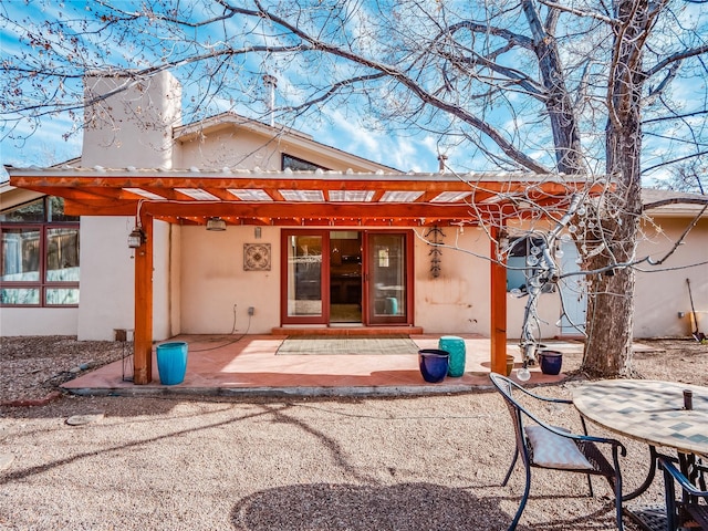 rear view of house featuring a pergola and a patio