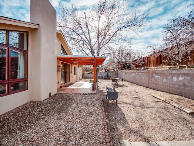 view of yard featuring a patio and an outdoor fire pit