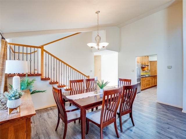 dining space featuring an inviting chandelier, high vaulted ceiling, and hardwood / wood-style floors